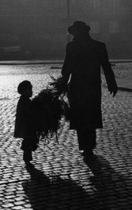 Father and son carrying tree in street